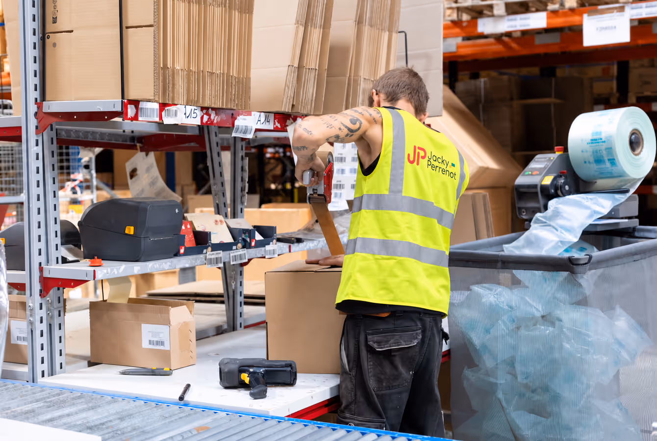 Poste de préparation de commandes, opérateur devant les étagères de picking