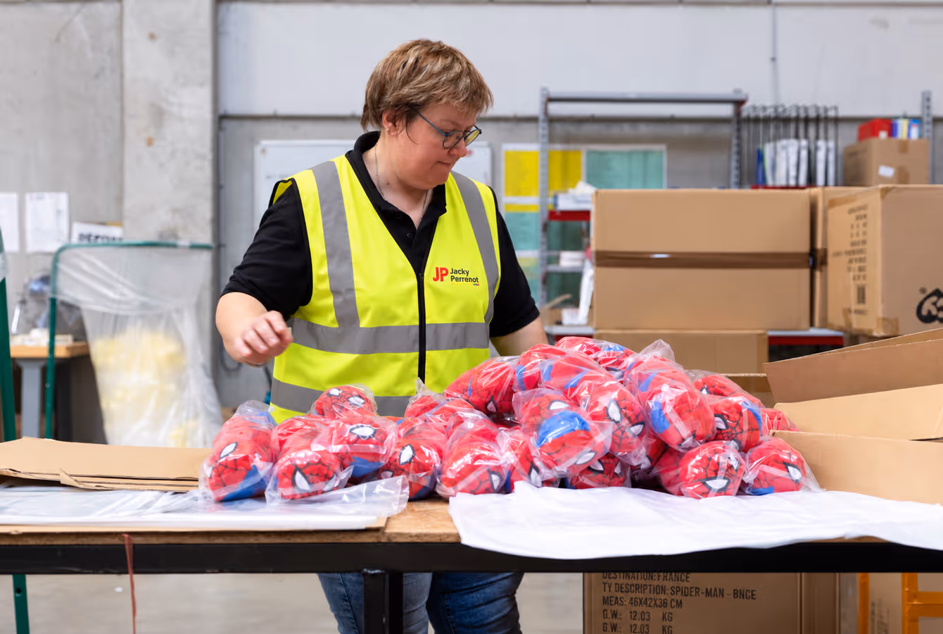 Opératrice reconditionnant des sachets sur une table de conditionnement